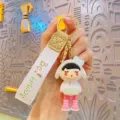 Trendy electroplated cute girl doll keychain with woven strap and gold ring accessory variant. - White