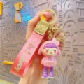 Cute cartoon girl keychain with pink strap, trendy plated doll key ring for bags and keys. - Pink
