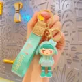 Cute cartoon girl keychain with green lanyard and metal ring bag charm accessory. - Green