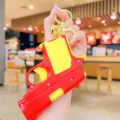 Portachiavi pistola giocattolo decompressione rosso giallo simpatico ciondolo borsa. - Rosso
