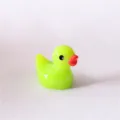 Primer plano de adorno de pato de resina verde neón, perfecto para decorar fundas de teléfonos móviles. - Verde Caramelo