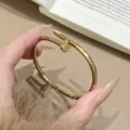 Elegantes goldenes Armband aus Titanstahl in Nagelform, stilvoller und langlebiger Damenschmuck. - Gold Vierblättrige Blume Nagel Armreif
