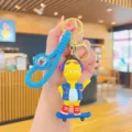 Schattige cartoon dinosaurus sleutelhanger met skateboard en koptelefoon in blauw - Trendy Dinosauriër - Blauwe Kleding Skateboard