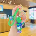 Leuke cartoon dinosaurus sleutelhanger variant met gitaar, stijlvolle tasbedel en accessoire. - Trendy Dinosauriër - Paarse Kleding Gitaar