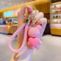 Cute pink knitted bear keychain with heart pendant, stylish bag charm and car key ring accessory. - Pink