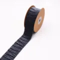 Detailed close-up view of dark textured velvet ribbon roll on cardboard spool for crafts. - Gray