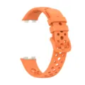 Close-up detail of orange perforated silicone watch strap, breathable sports band design. - Orange