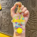Clear water ring toss game keychain, transparent cup shape toy with golden ring hook, compact and fun. - Cake Water Game - Yellow