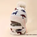 Kids dinosaur knit hat and scarf set with fleece lining and pom pom for winter warmth. - Off White
