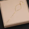 Dettaglio di una catena da mano in acciaio al titanio dorato con ciondoli a stella in zircone delicati. - Stile 8