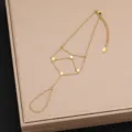 Primo piano dettaglio del bracciale da mano in acciaio dorato con ciondoli quadrati geometrici. - Stile 14