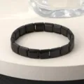 Gedetailleerd overzicht van de zwart roestvrijstalen modulaire armband met vierkante schakels. - Zwart