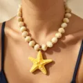 Closeup detail of a bohemian style yellow starfish pendant necklace with chunky acrylic beads. - Yellow