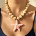 Detailed close-up of a stylish acrylic marbled bead necklace with a pink starfish pendant. - Light Pink