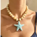 Close up of acrylic starfish pendant beaded necklace, detailed view of summer beach jewelry. - Blue