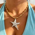 Close-up detailed view of the irregular silver star pendant and gold beaded necklace. - Two-Tone 1#