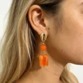 Close-up detail of French retro contrast resin earrings featuring gold shell studs and blocks. - Orange