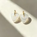 Detailed view of translucent resin heart pendant with gold hoop earrings for women style. - White