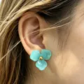 Detailed close-up of blue resin flower stud earrings, sweet floral design for daily wear. - Blue