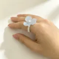 Close-up detail view of the elegant blue resin flower ring featuring delicate pearl band design. - 2#