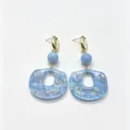 Gros plan détaillé de boucles d'oreilles pendantes ovales en résine marbrée rétro et chic. - Taille 6