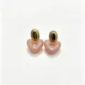 Close-up detail of the pink marbled resin heart pendant paired with textured gold oval stud. - Pink