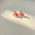 Detailed view of fashionable resin flower stud earrings with sweet pink petals and gold center bead. - Light Pink