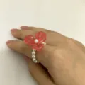 Detailopname van de roze harsbloem en parel elastische ring in Koreaanse stijl. - Maat 6