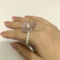 Detailopname van de paarse hars bloem en parel kralen stretch ring op de hand. - Maat 7