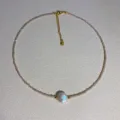 Dainty beaded choker necklace featuring a large iridescent pearl pendant and metal extension chain. - Style 1