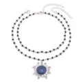 Detailed view of a double-layered black beaded necklace featuring a blue stone sun pendant. - Blue