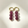 Close-up detail of stylish gold hoop earrings featuring elegant purple natural stone beads. - No.4 Gold