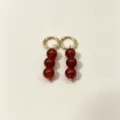 Detailed shot of gold-plated hoop earrings featuring three dangling red agate round beads for women. - No.5 Gold