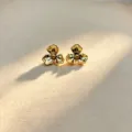 Golden flower stud earrings detail view, showcasing intricate petal design and glossy finish. - Gold