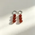 Close-up detail of elegant red stone bead hoop earrings with polished metal rings. - No.5 Silver