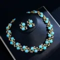 Detailed close-up view of a luxury blue pearl and gold leaf rhinestone necklace and earrings set. - Blue Artificial Pearl Set