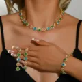 Primo piano dettagliato del set di gioielli in cristallo indossato su collo, mano e polso. - Set da 3 Pezzi (HB090-3) / Collana + Orecchini + Bracciale / Colorato