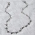 Detalle de cadena de metal plateado estilo punk, con colgantes de picos para looks audaces. - k2-k556