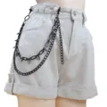 Shorts vaqueros beige de estilo punk combinados con una cadena de cintura de tachuelas de metal negro. - Cadena Para Pantalón De Doble Capa Con Tachuelas Negras