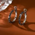Vista di dettaglio di orecchini a cerchio argentati minimalisti con strass neri brillanti ed eleganti. - 2.5cm / Canna di fucile