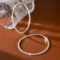 Vista di dettaglio ravvicinata di grandi orecchini a cerchio argentati con strass brillanti. - 8.5cm / Argento