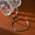 Primo piano di grandi orecchini a cerchio con strass neri, finitura metallica brillante. - 8.5cm / Canna di fucile