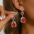 Raffinati orecchini pendenti in cristallo rosso con strass scintillanti e design floreale. - Orecchini / Rosso
