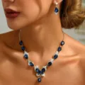 Primo piano dettagliato ed elegante della collana con farfalla in cristallo blu e orecchini. - Stile Ciondolo Farfalla (80804329)