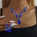 Primo piano dettaglio del lussuoso set di gioielli con collana e orecchini in strass blu. - Stile Pendente Squisito (80835308)