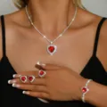 Primo piano dettagliato di un elegante set di gioielli tennis con strass a cuore rosso brillante. - Set da 4 pezzi rosso