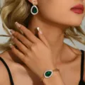 Dettaglio ravvicinato di lussuosi orecchini in cristallo a goccia verde e bracciale. - Orecchini Verdi E Bracciale (83848703)
