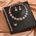 Primo piano dettagliato di un bellissimo set di gioielli in cristallo rosso con collana e orecchini. - Stile Set Quattro Pezzi Petalo (80868603) / Rosso