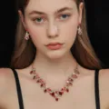 Dettaglio di uno splendido set di collana e orecchini in cristallo rosso con design floreale. - Stile Foglia Floreale Intrecciata (80820803)