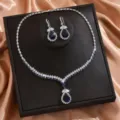 Vista dettagliata della parure da sposa con collana e orecchini in zirconi blu brillanti. - Stile Goccia d'Acqua Blu Scuro (80856108)